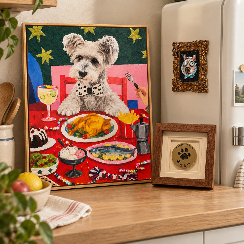 A colorful framed pet portrait and a brass paw-print frame on a warm oak counter, with a clay pet magnet on the refrigerator.